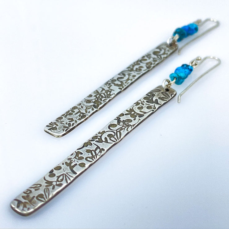 Sterling Silver Floral Bar Earrings with Turquoise Beads laying diagonal