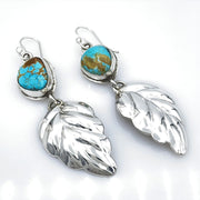 Royston Turquoise and Sterling Silver Repoussé Leaf Earrings laying diagonal