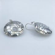 Sterling-Silver-Floral-Textured-Domed-Medallion-Earrings closeup of french ear wire