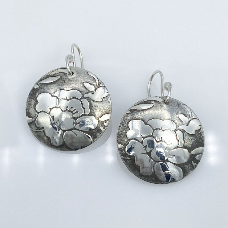 Sterling-Silver-Floral-Textured-Domed-Medallion-Earrings laying flat