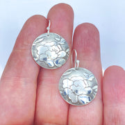 Sterling-Silver-Floral-Textured-Domed-Medallion-Earrings size comparison to hand