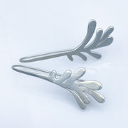 Sterling Silver Modern Leaf Threader Earrings laying diagonal