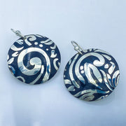 Sterling Silver Swirl Textured Domed Medallion Earrings laying flat